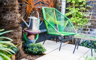 Feature green chair in garden near palm tree